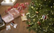 Close-up of Christmas bauble on tree with lights.